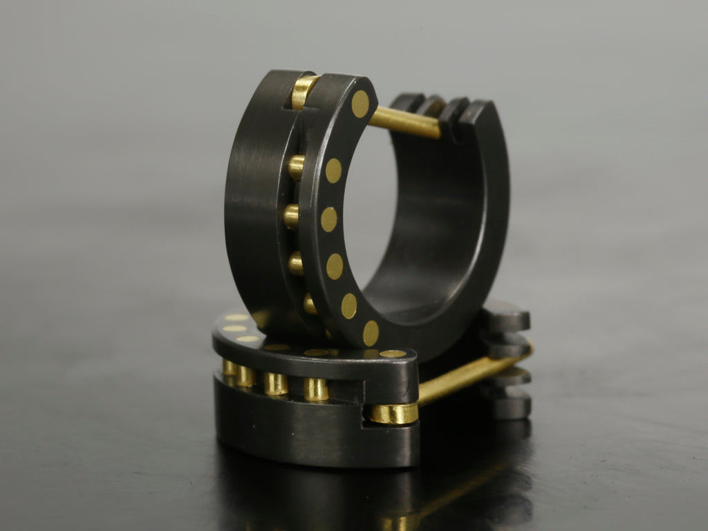 Zirkonium oorbellen met geelgouden pennen en zwarte achtergrond