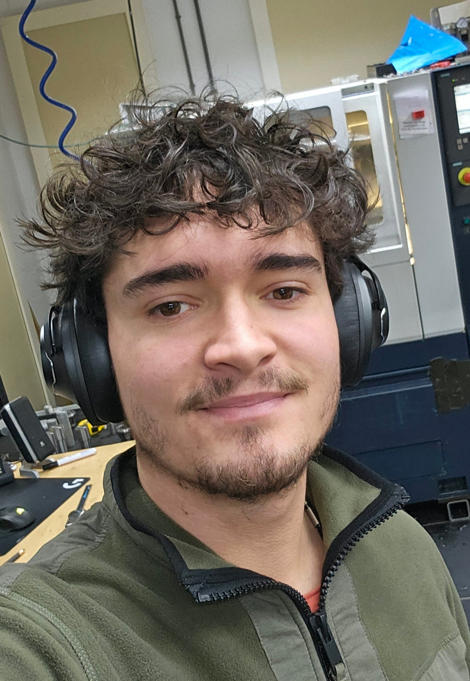 Wouter Dijkman aan het werk in de werkplaats van Metal Art Sieraden, omringd door gereedschap en machines.