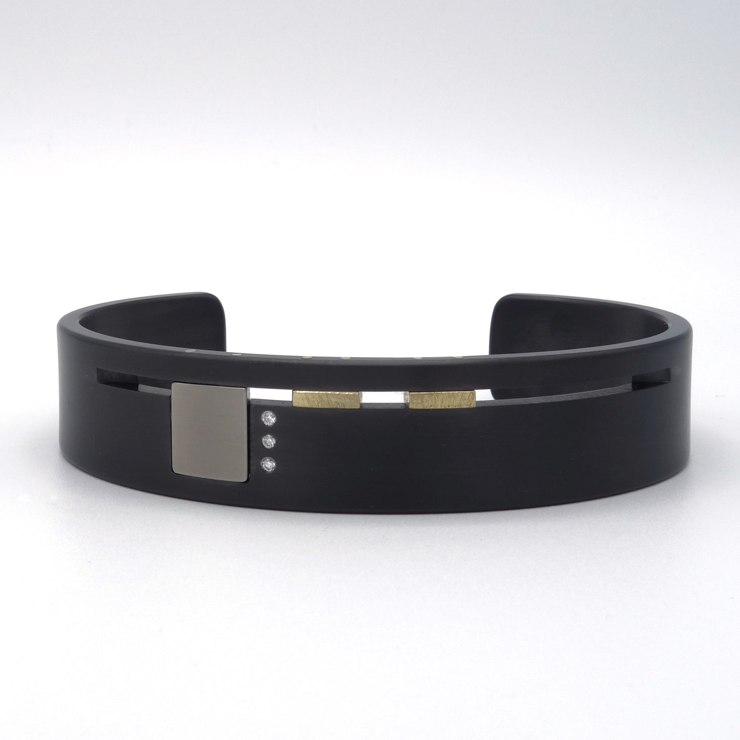 Design armband van zirkonium met titanium, geelgoud en drie diamanten – modern en grafisch ontwerp met architectonische details.