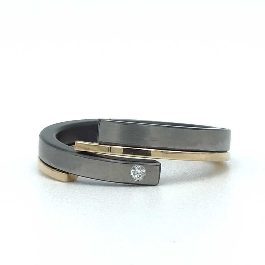Dubbele Helix-ring van zirkonium en 18kr geelgoud met 0.015 ct diamant.