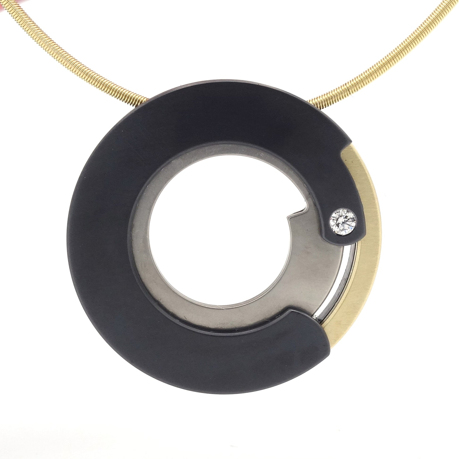 Ronde hanger van zwart zirkonium en roodgoud met een 0,05 ct diamant, modern design aan een metalen ketting.