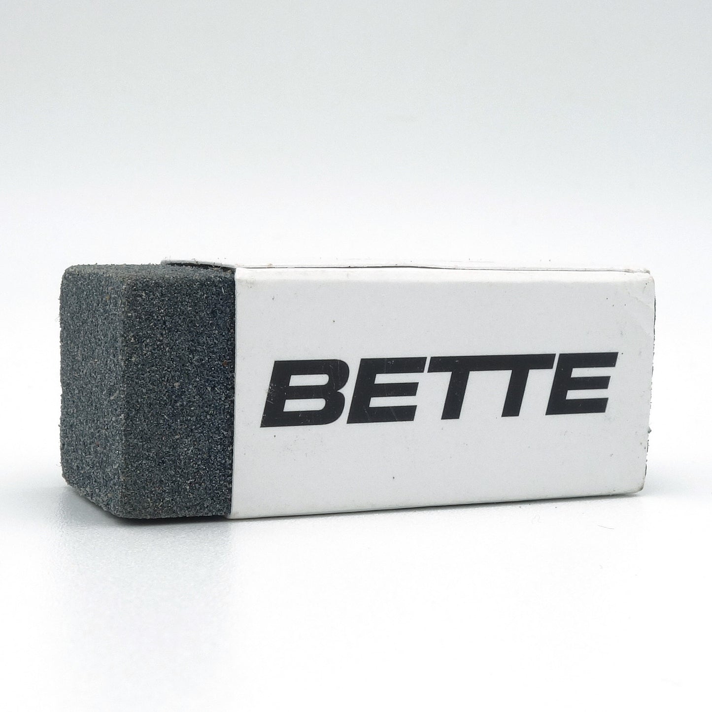 Bette sanitair gum voor het verwijderen van zwarte metaalstrepen op toilet en wastafel, close-up op witte achtergrond