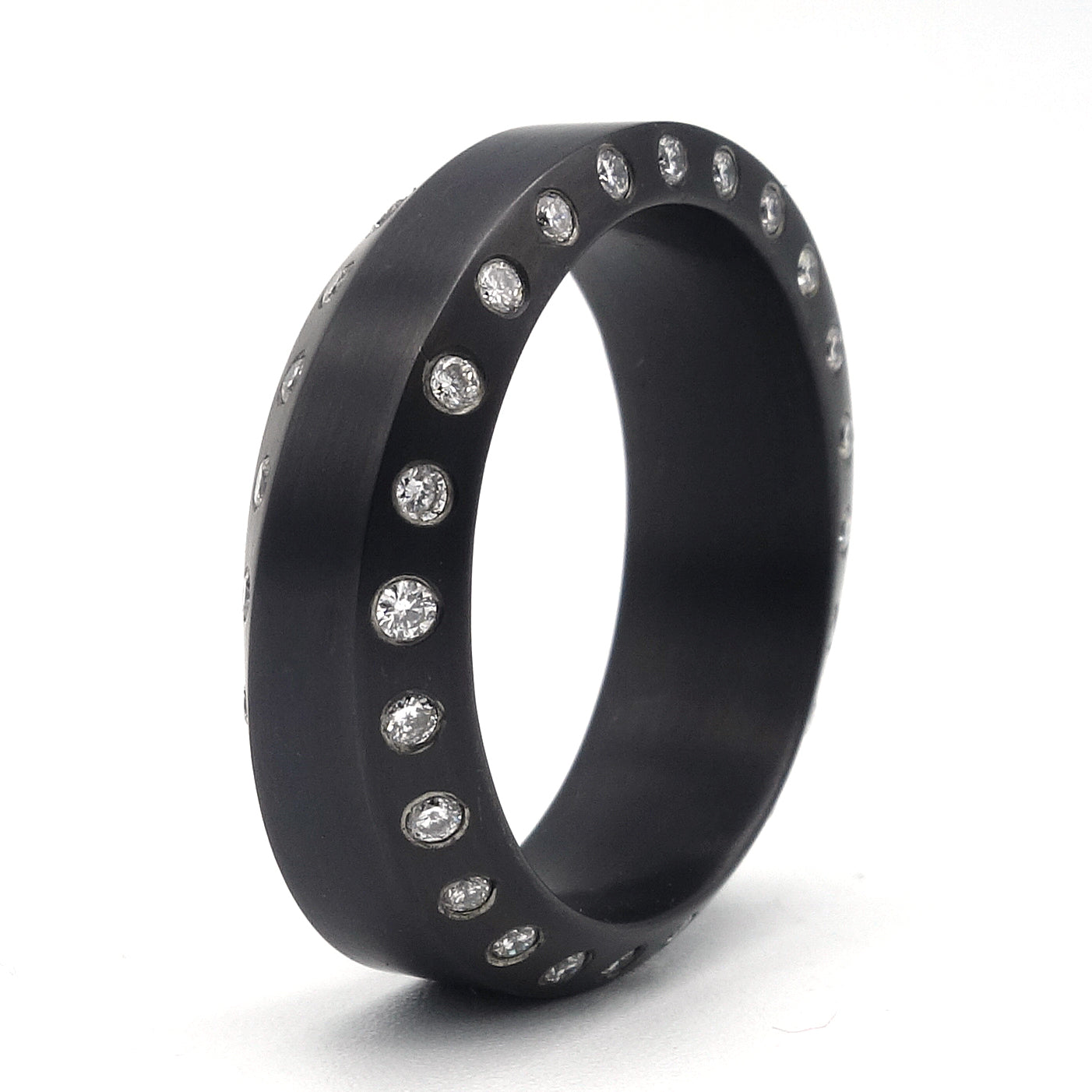 Zwarte zirkonium ring met golvend profiel, rondom bezet met 48 briljanten in twee banen langs de randen.