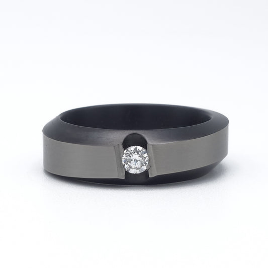 Zirkonium ring met matte bovenzijde, golvend profiel en briljant in spanningszetting.