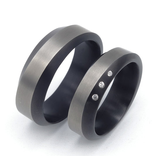 Set van twee zirkonium trouwringen, één met drie diamanten en één zonder stenen, met golvend profiel.