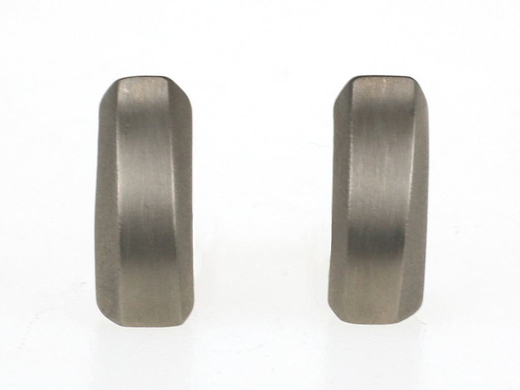 Matte titanium oorbellen met geometrisch ontwerp en licht golvende vorm.