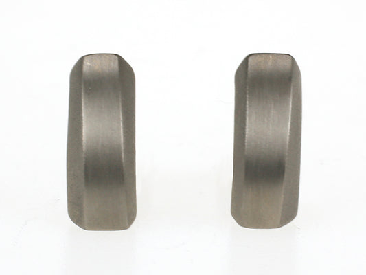 Matte titanium oorbellen met geometrisch ontwerp en licht golvende vorm.