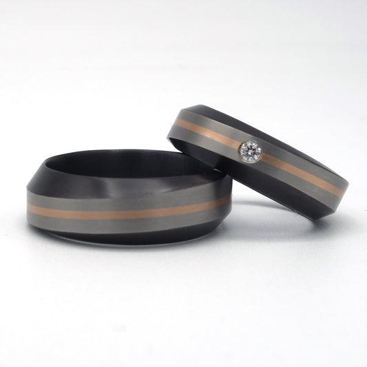 Set zirkonium trouwringen met grijze band en 0,8 mm roodgouden inleg; één ring met diamant, één zonder.