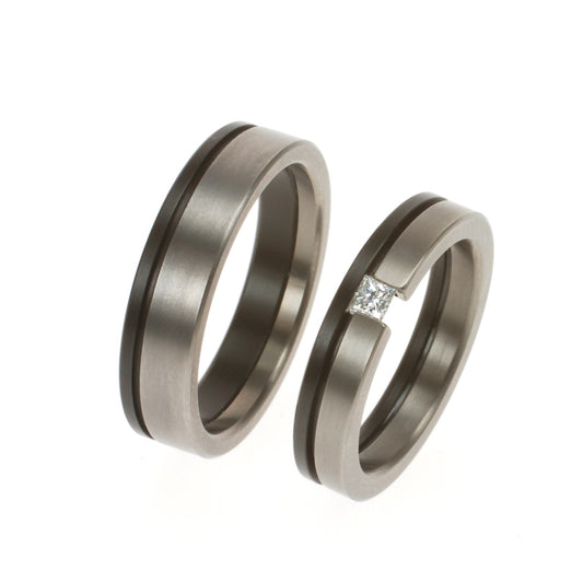 Trouwringenset van titanium en zwart zirkonium, met princes geslepen diamant van 0.12 ct in de damesring.