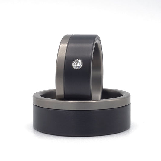 Zwart-Wit ringenset van titanium en zirkonium – moderne contrastcombinatie met subtiele diamant in de damesring.