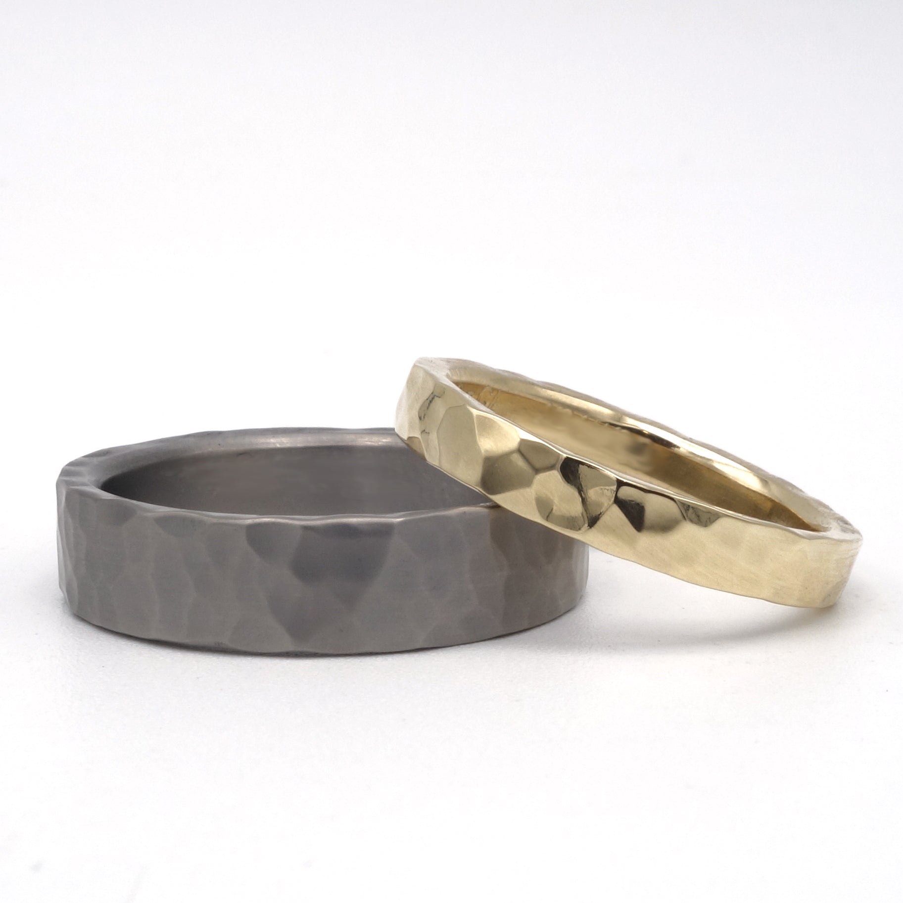 Bol Hamerslag trouwringen set: titanium herenring 5 mm en 14kr geelgouden damesring 3 mm, beide met hamerslag patroon.