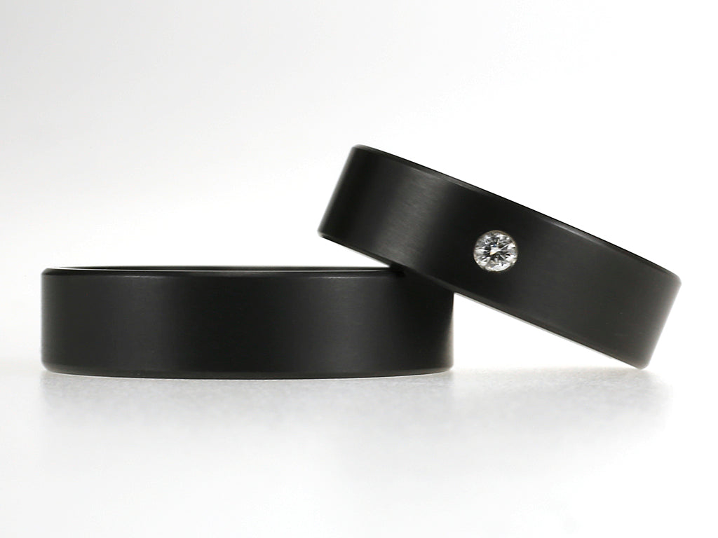 Noir trouwringen van zwart zirkonium, 6 mm breed, waarvan één ring met een diamant van 0.05 ct.