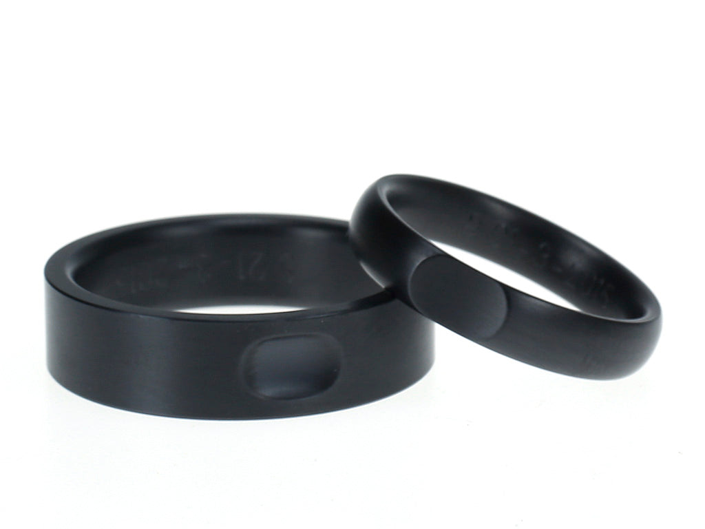 Zwart zirkonium ringen met contrasterende vormen – een vlakke ring met bolle inkeping en een bolle ring met vlakke uitsparing.