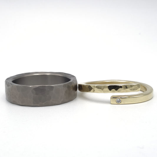 Stoere titanium ring met hamerslagstructuur en verfijnde geelgouden damesring met diamant van 0,01 ct en deels hamerslag.