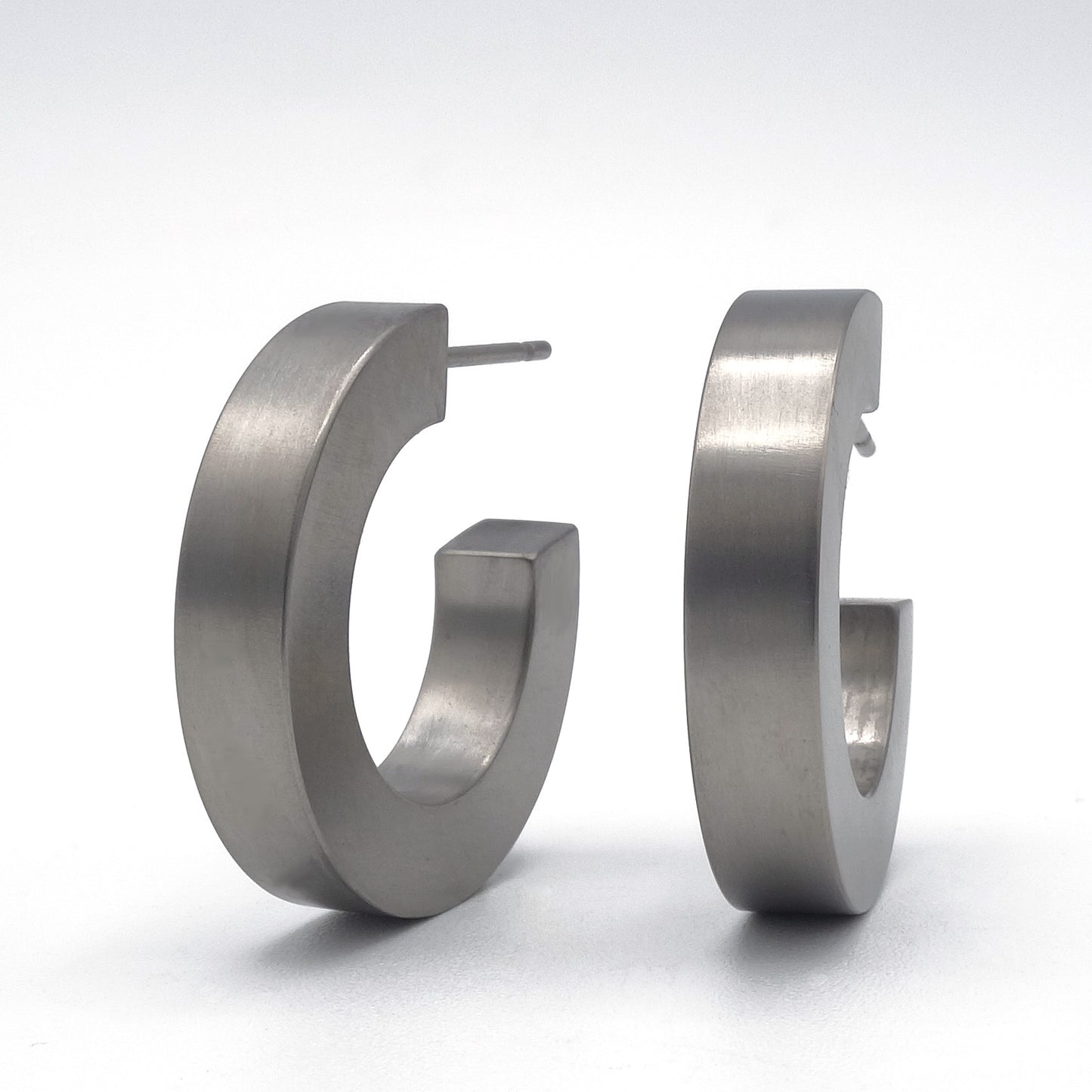 Grijze titanium creolen, 21 mm groot en 4 mm breed, met titanium stekers