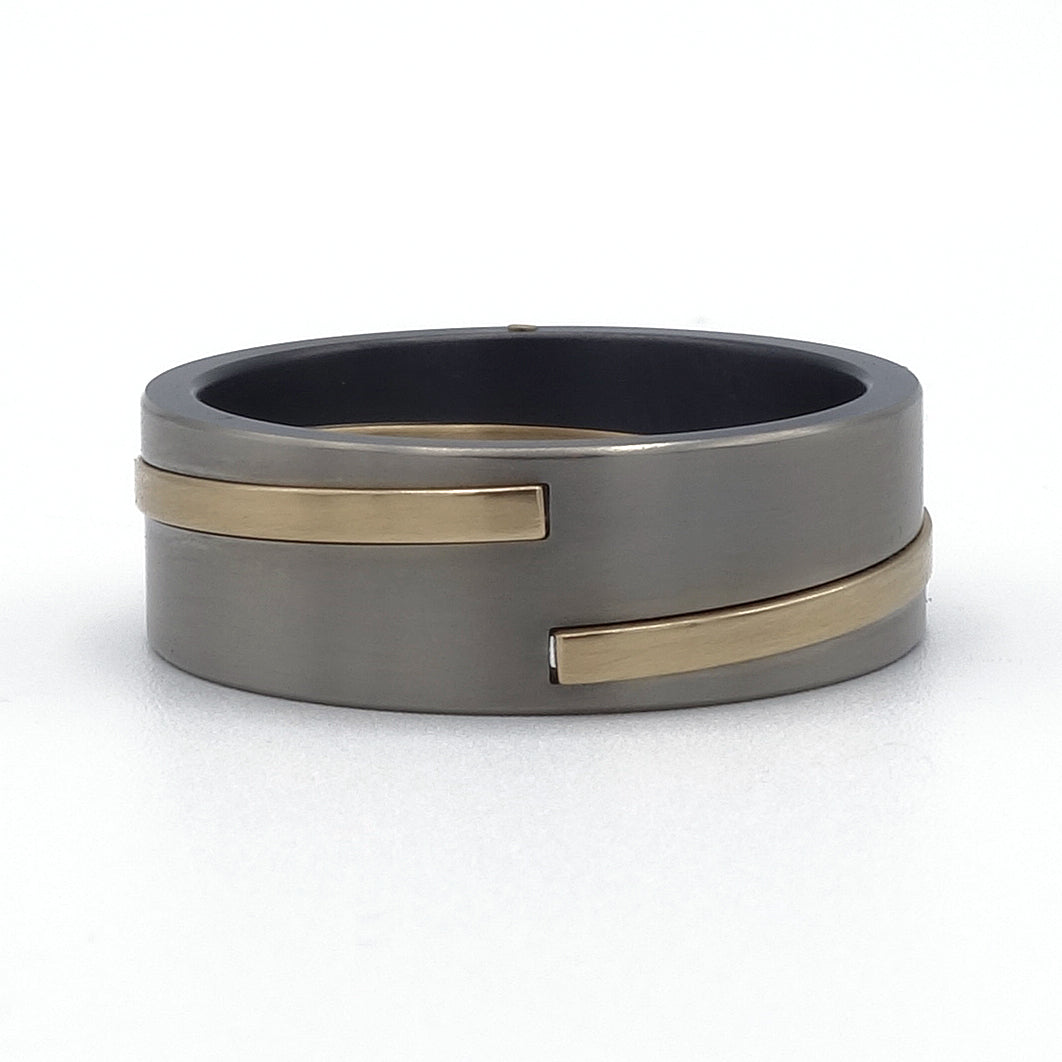 Elica ringenset van zirkonium en geelgoud – elegant gedraaid ontwerp met modern materiaalcontrast.