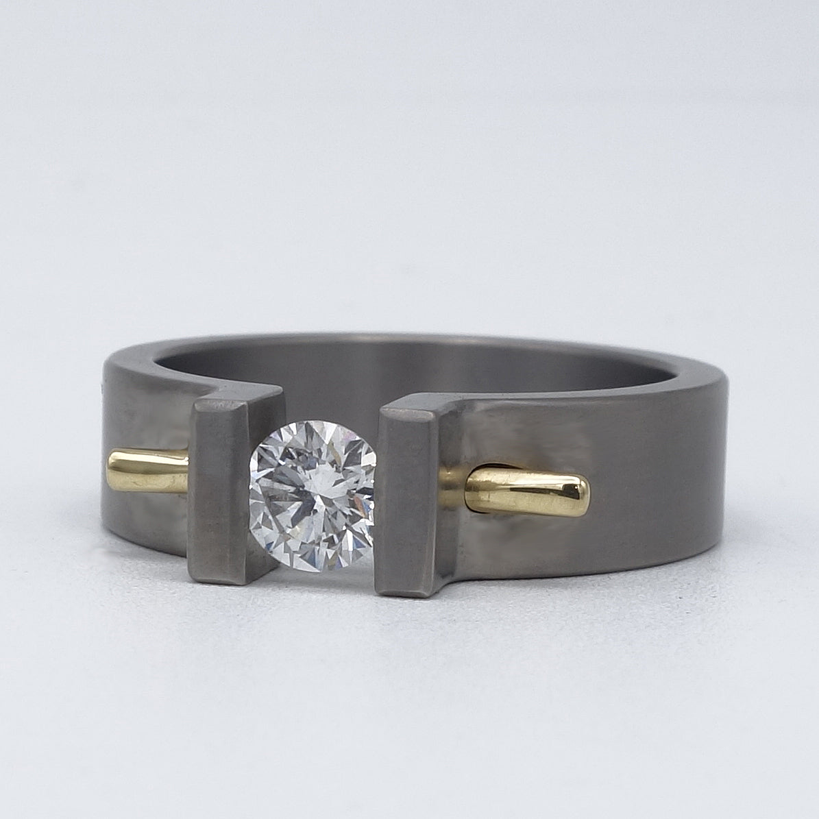 Moonrise ring van titanium met diamant en geelgouden pen als accent.