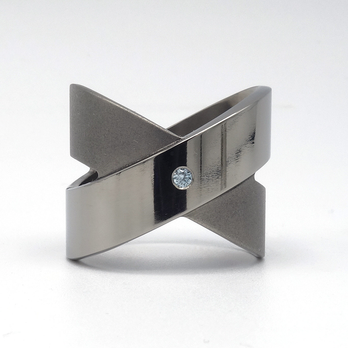Titanium crossring in gesloten X-vorm met blauwe diamant Ice 0,05ct glad omgezet, Lea II van Metal Art Sieraden.