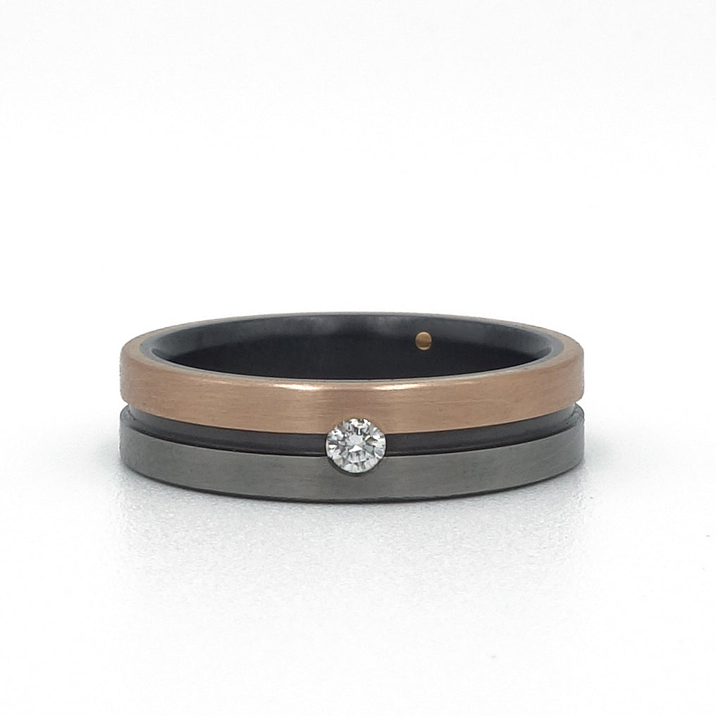 Lines-ring van zirkonium en 18k roodgoud – strak ontwerp met subtiele diamant en modern kleurcontrast.