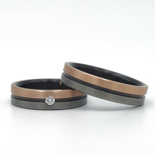 Lines ringenset van zirkonium en 18k roodgoud – moderne trouwringen met strak lijnenspel en warm roodgouden detail.