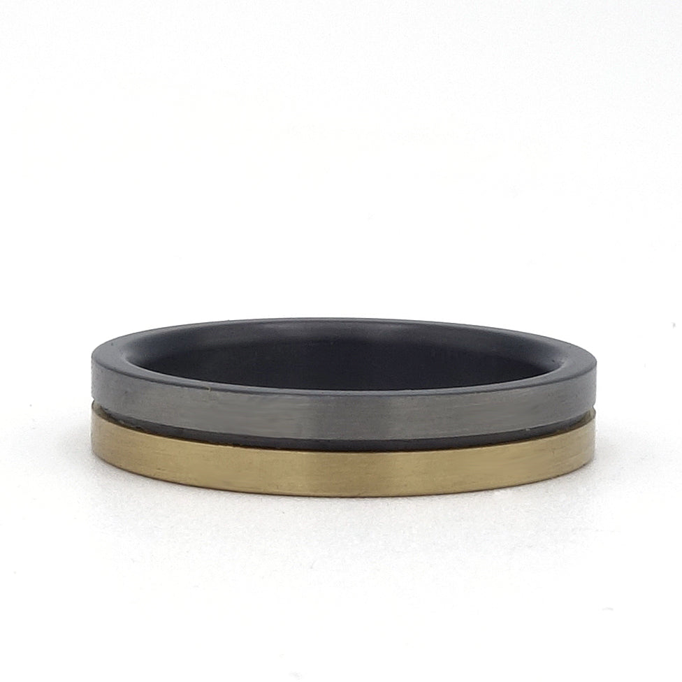 Lines-ring van zirkonium en geelgoud – 4 mm smalle ring met strak lijnenspel en modern contrast tussen materialen.