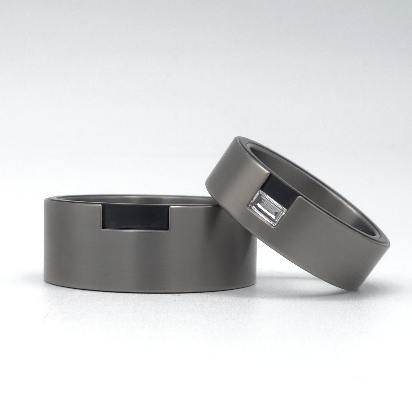 Brede titanium trouwringen met baguette diamant en zicht op zwarte zirkoniuminleg