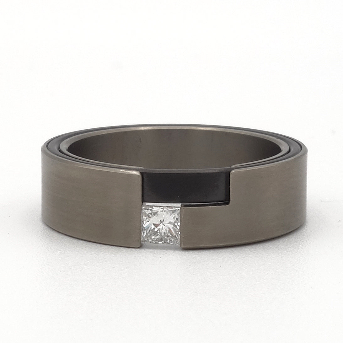 Leona-ring van titanium en zwart zirkonium met prinsesgeslepen diamant – moderne damesring met grafisch contrast.