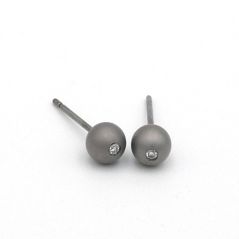 Bolvormige oorbel van titanium met kleine diamant in het midden 0.01 ct. Maat oorbel is 4.75 mm