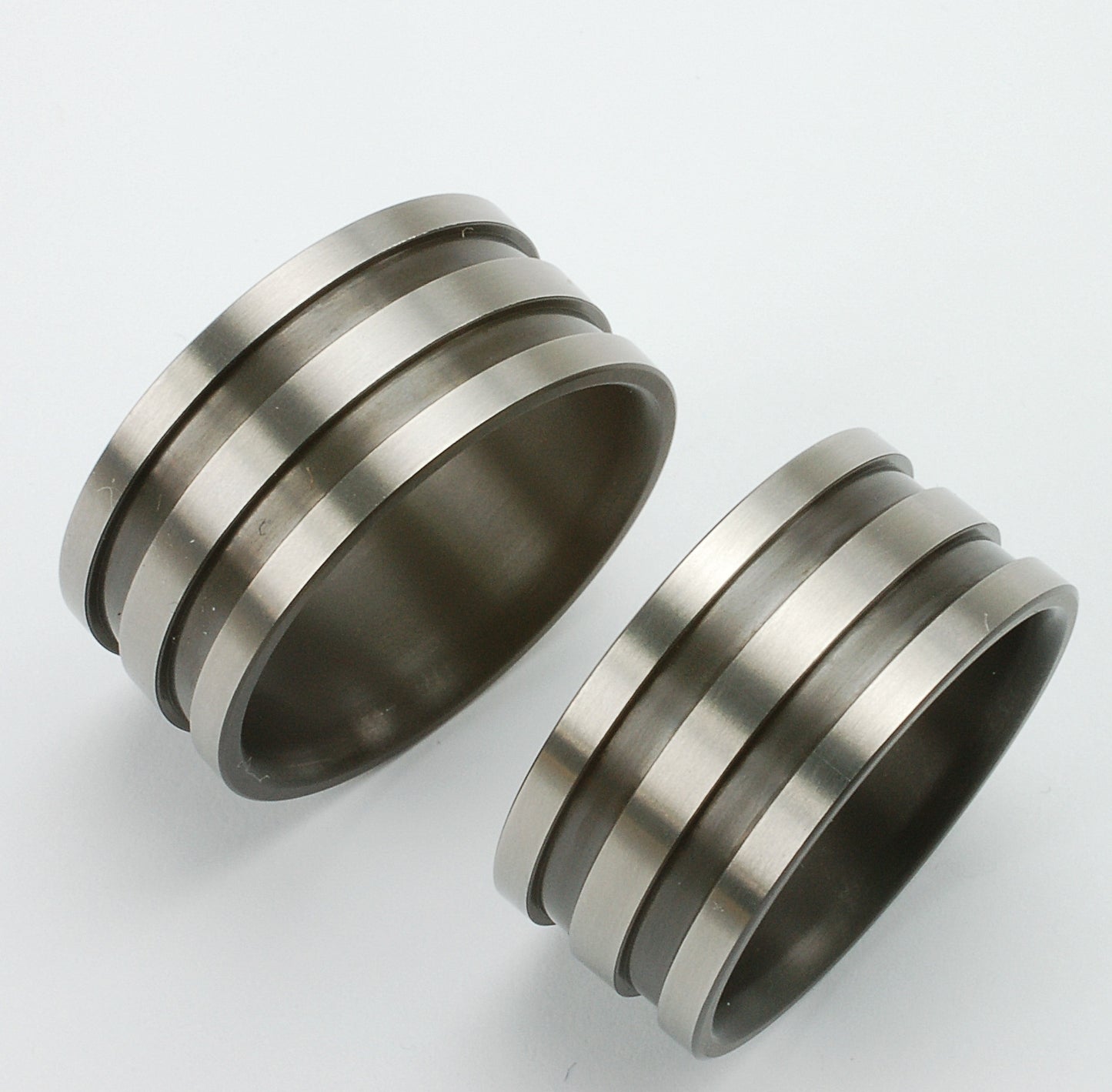 Twee matte zirkoniumringen met drie strakke groeven in modern industrieel design