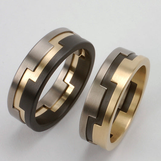Trouwringenset met in elkaar grijpende segmenten van geelgoud, titanium en zwart zirkonium