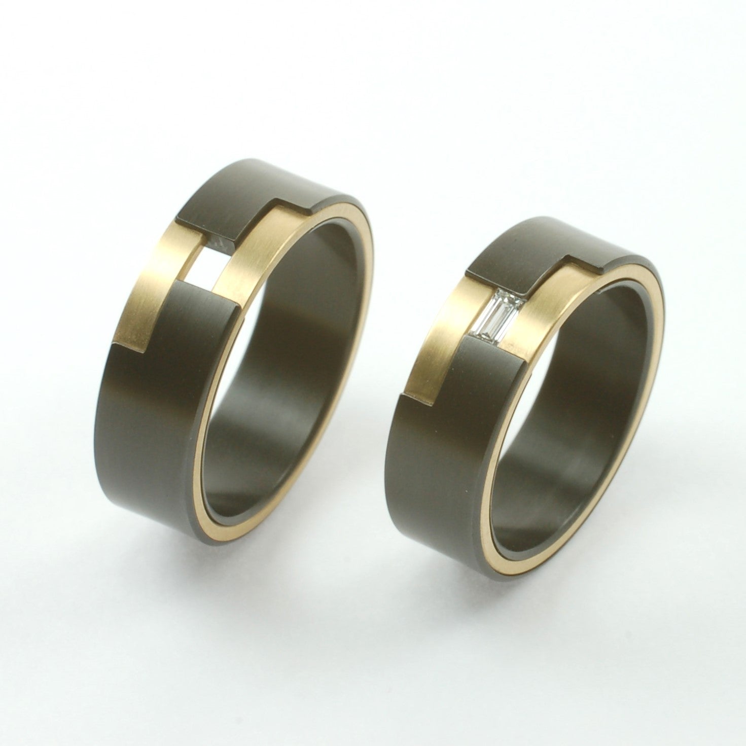 Set trouwringen van zirkonium en 14kr geelgoud, met geometrisch design en baguette-geslepen diamant.