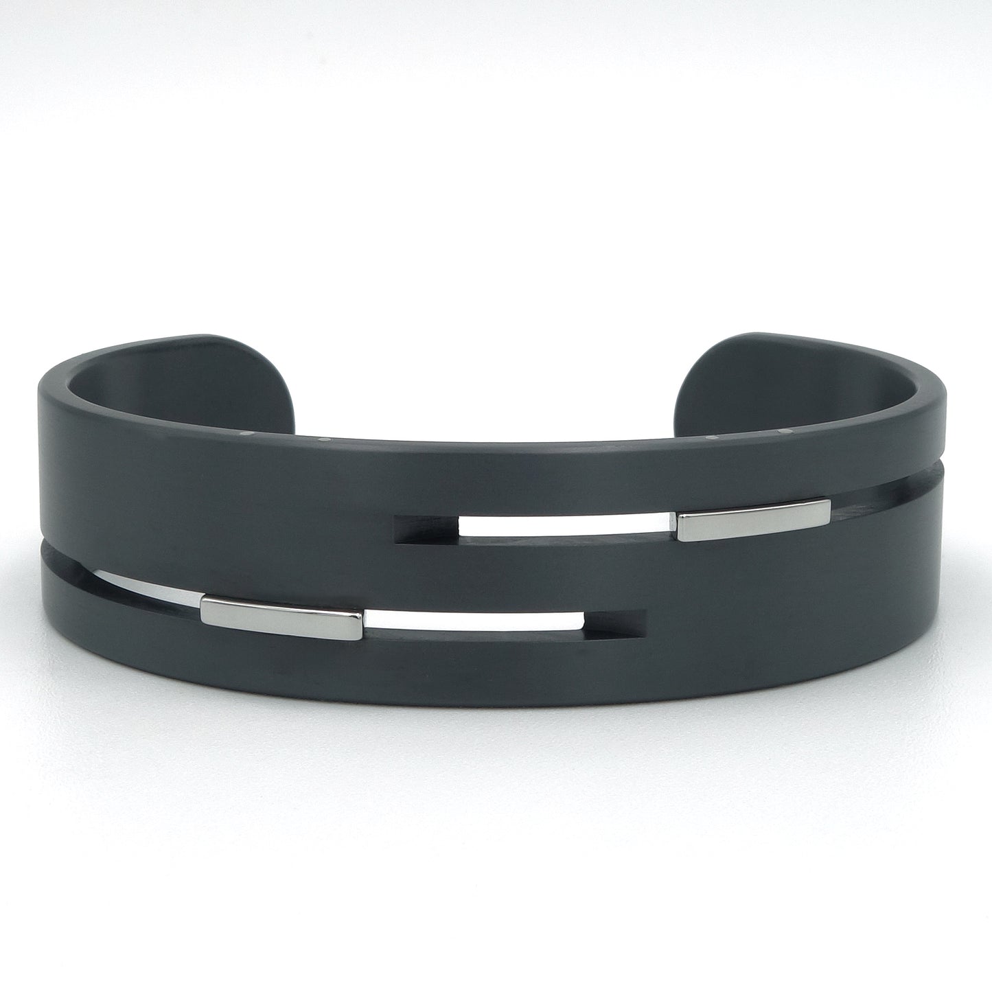 Brede open bangle van zwart zirkonium met gepolijste edelstalen inserts in horizontale gleuven, 18mm breed, mat afgewerkt.