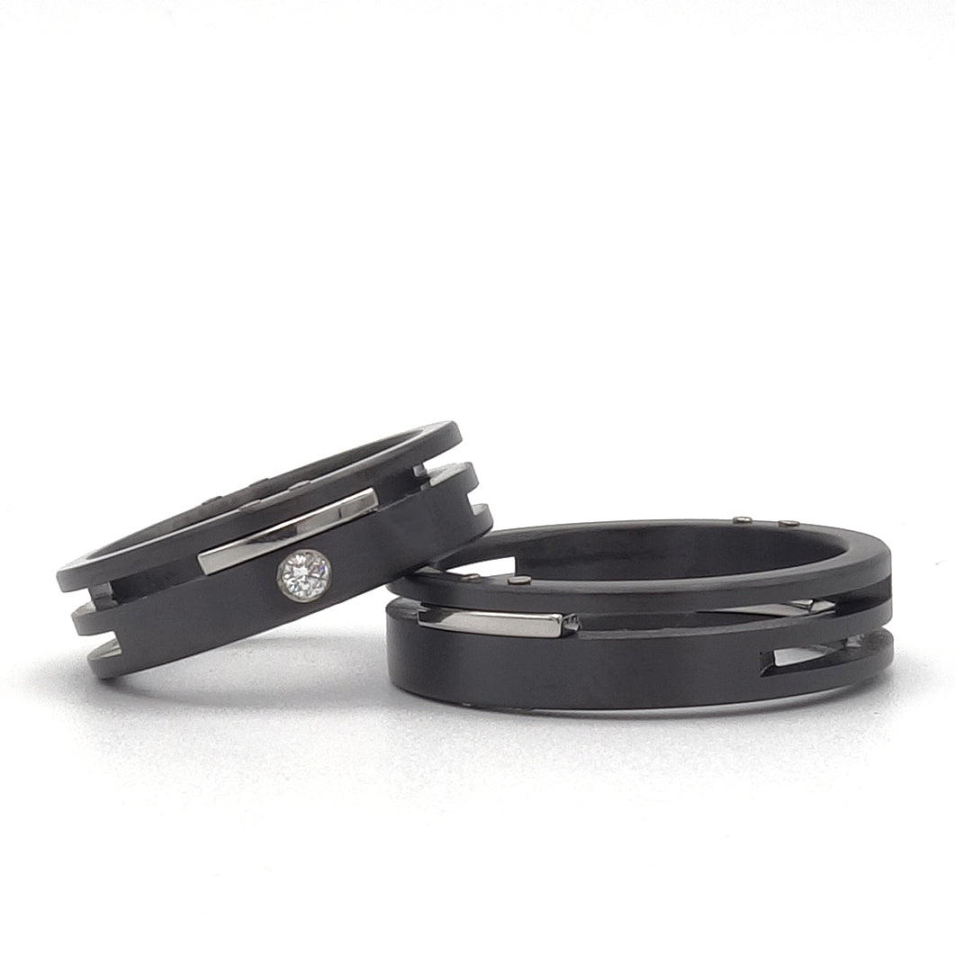 Split-Level ringenset van zirkonium en edelstaal – moderne set met gelaagd ontwerp, waarbij de damesring is voorzien van een diamant.