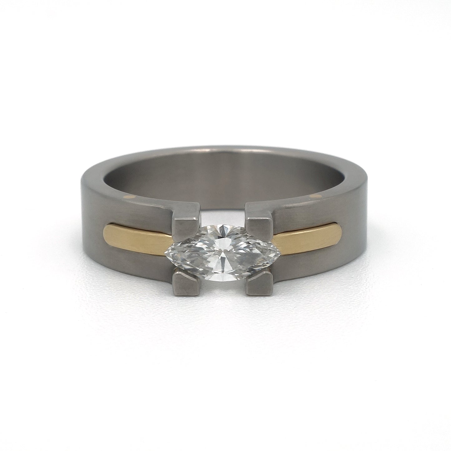 Damesring Sunrise van titanium en 18-karaat geelgoud met marquise diamant in optische spanzetting.