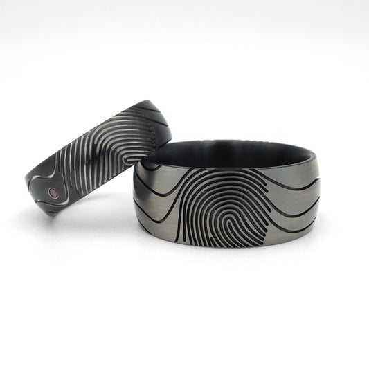 Vingerafdruk Contra trouwringen van zirkonium met artistieke vingerafdrukken en diamant van 0.015 ct.