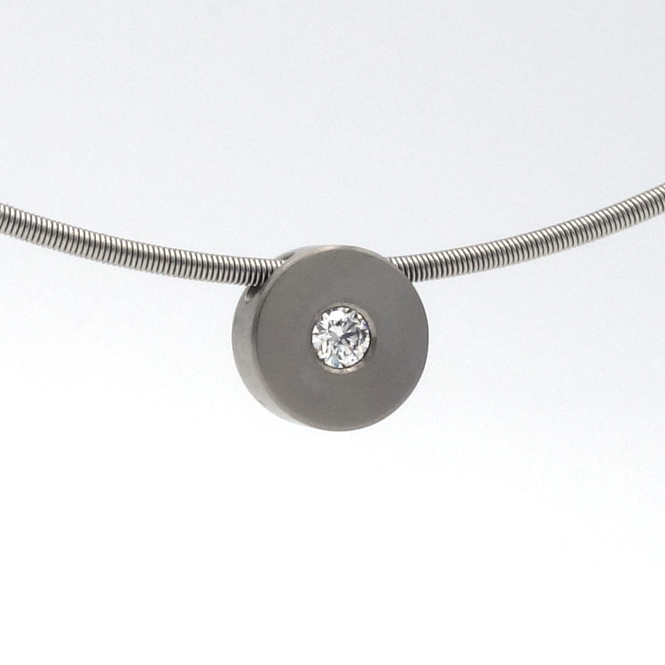 Titanium hanger van 8,5 mm met witte diamant van 0,08 ct, bevestigd aan een metalen slangenketting.