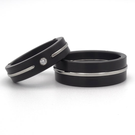 Zwarte trouwringen van zirkonium met glanzend stalen inleg; damesring met 0.05 ct diamant