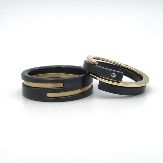 Moderne trouwringenset van zwart zirkonium met 18kr geelgouden accenten en diamant van 0,015 ct in de damesring.