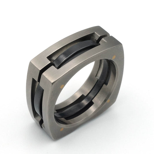 Vierkante ring van titanium met zwarte zirkonium kern en geelgouden pennen – strak technisch ontwerp
