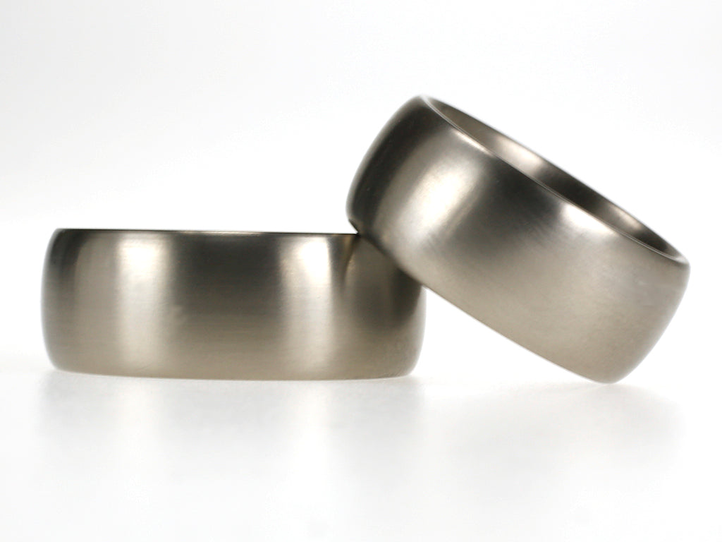 Brede titanium trouwringen van 9 mm met bol profiel en matte afwerking.
