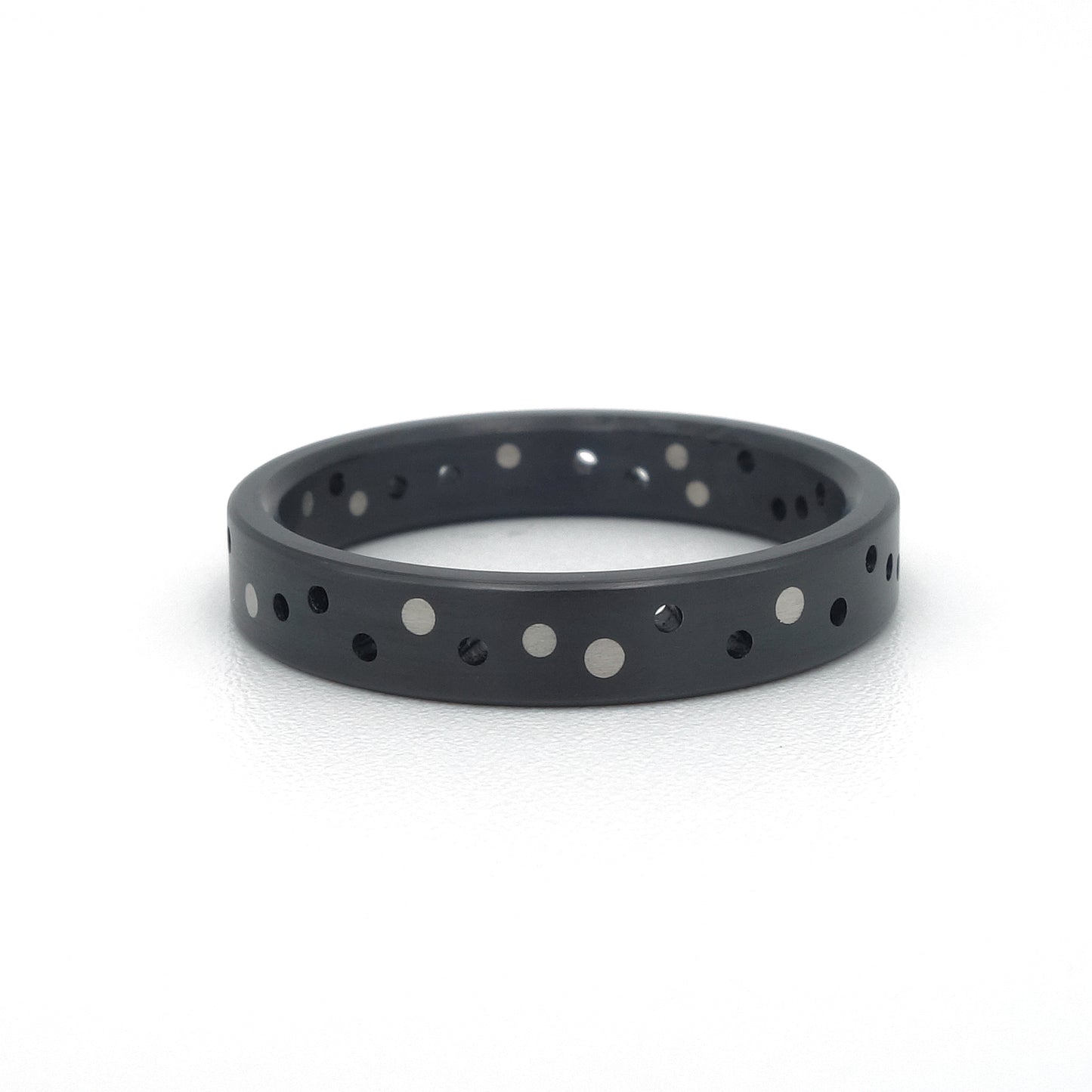 Zwarte zirkonium ring Confetti Black met willekeurig patroon van platina stippen.
