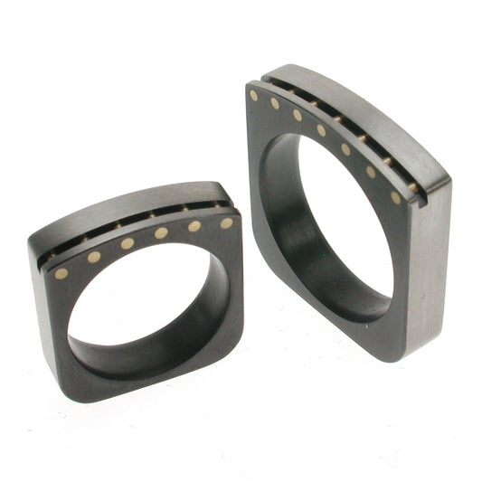 Vierkante trouwringen van zwart zirkonium met 18kr geelgouden pennen en geborsteld oppervlak