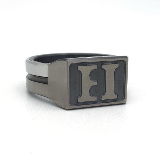 Moderne zegelring in grijs en zwart zirkonium met edelstalen band. Rechthoekige zegelplaat met verdiept gefreesd initialen, geschikt als stempel in zegellak.