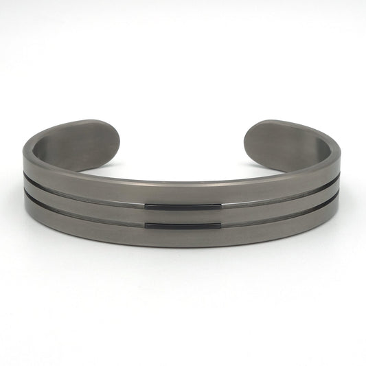 Open armband van titanium met twee zwarte zirkonium lijnen, 13mm breed, op witte achtergrond