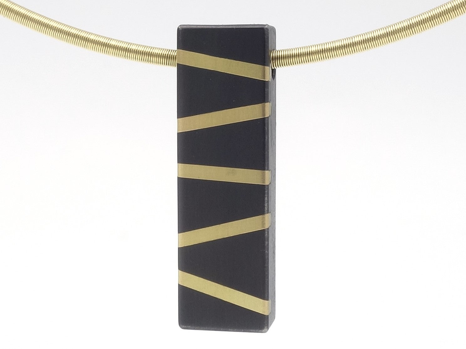 Hanger met een geelgoduen spang. hanger is van zirkonium met geelgouden inleg lijnen als een zebra