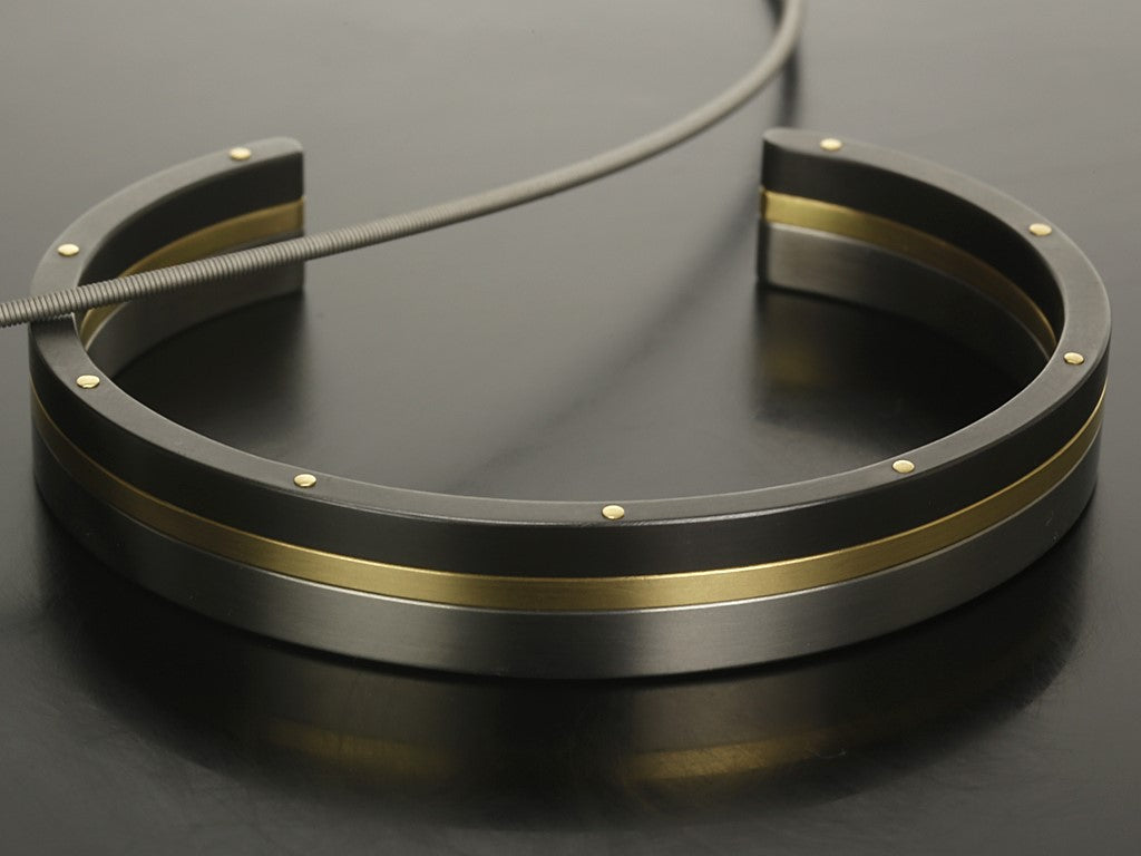 Exlusieve armband uit meerdere lagen. titanium zirkonium en geelgoud met klinknagels