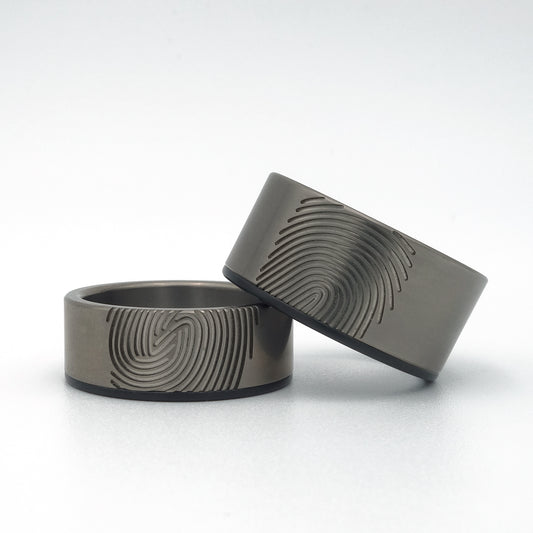 Titanium trouwringen met zwarte zirkonium rand en één vingerafdruk per ring.