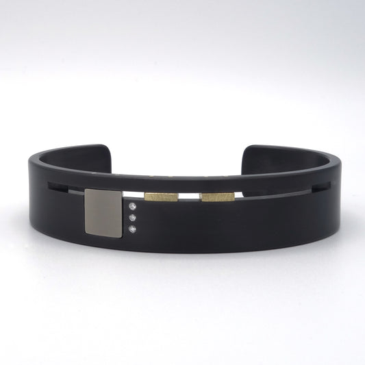 Design armband van zirkonium met titanium, geelgoud en drie diamanten – modern en grafisch ontwerp met architectonische details.
