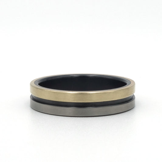 Lines-ring van zwart en blank zirkonium met een band van 14kr geelgoud – strak, modern en stijlvol.