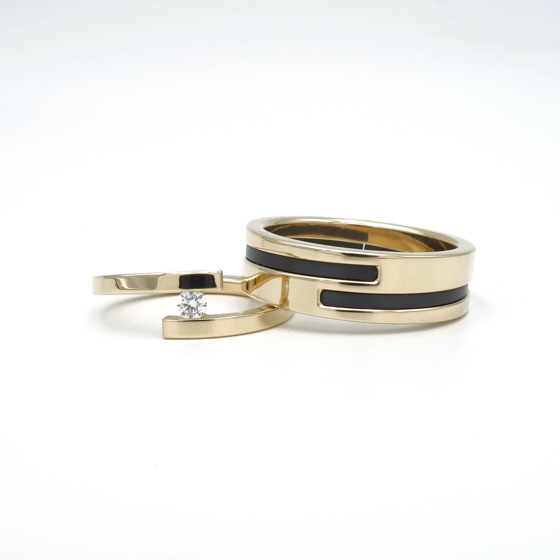 18 karaat gouden trouwringenset met zwarte zirkonium-inleg in de herenring en een open damesring met diamant van 0,10 ct.